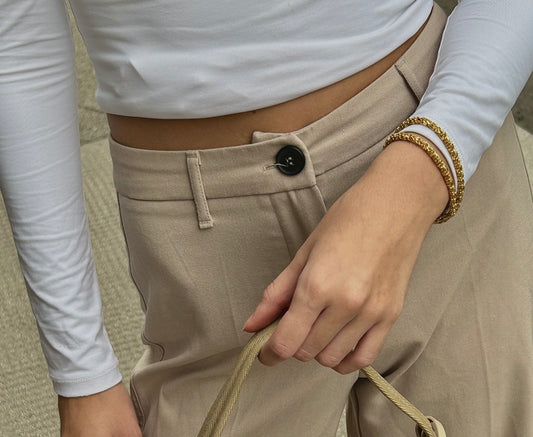 girl holding a bag and wearing some beautiful gold bracelets